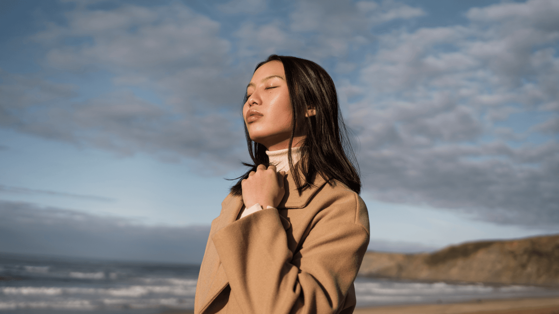 A woman pausing peacefully by the coast